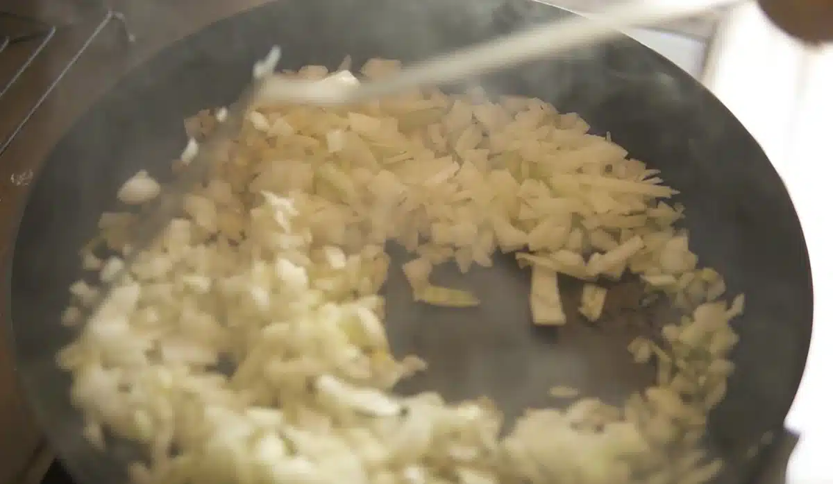 フライパンで玉ねぎを炒めている